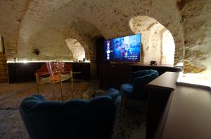une chambre avec des chaises et une télévision dans une grotte dans l'établissement Secret Jacuzzi Mons - Parking privé gratuit, à Mons