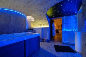 uma casa de banho azul com uma banheira e um lavatório em Secret Jacuzzi Mons - Parking privé gratuit em Mons