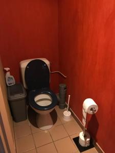 a bathroom with a toilet with a black seat at Chambres d hôtes 