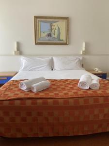 1 dormitorio con 1 cama con 2 toallas en Hotel Rosapineta - Adults Only en Lignano Sabbiadoro