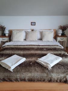 a large bed with two white towels on it at Apartmán Mikulov in Mikulov