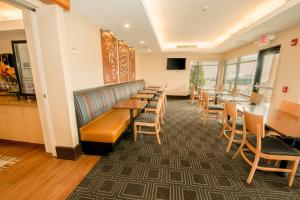 TownePlace Suites by Marriott Scranton Wilkes-Barre في Moosic: غرفة انتظار مع صف من الطاولات والكراسي