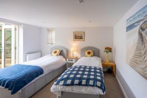 two beds in a room with a window at Stone Lodge in Hunstanton