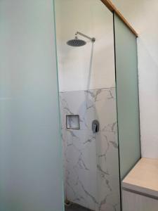 y baño con ducha y puerta de cristal. en MAIMALU BEACH VIEW, en Airsatang