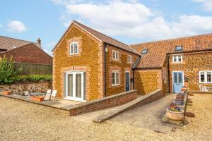 a brick house with a patio in front of it at Stone Lodge in Hunstanton