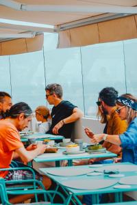 Millennium Hub & Hotel في كونستانتا: مجموعة من الناس يجلسون على الطاولات يأكلون الطعام