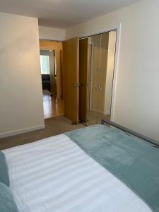 a bedroom with a bed and a door to a hallway at 2 bed city centre executive apartment in Aberdeen