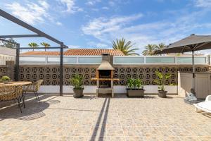 een patio met een open haard en een tafel en stoelen bij CANARIAN HOLIDAY HOME - Private Bungalow in Playa del Inglés in Maspalomas