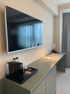 a kitchen with a counter with a tv on the wall at Millennium Hub & Hotel in Constanţa