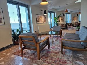 a living room with chairs and a table and windows at Millennium Hub & Hotel in Constanţa