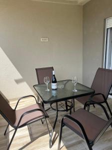 un tavolo con due bicchieri di vino e due sedie di Apartmani Vivami a Budua