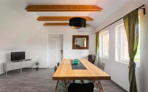 una sala da pranzo con un tavolo e una tv di Patakpart Vendégház a Egerszalók