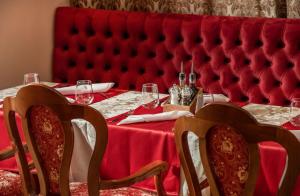 a table with a red tablecloth and two chairs at a table with glasses at Hotel Cvita in Split