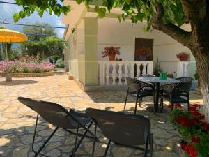 a patio with a table and chairs under a tree at Vjosa Guest House in Memaliaj