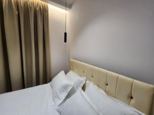 1 dormitorio con 1 cama con sábanas y almohadas blancas en Sea Front Villa en Vlorë