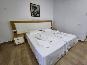 ein Schlafzimmer mit einem weißen Bett und Handtüchern darauf in der Unterkunft Sea Front Villa in Vlorë