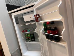 a porta do frigorífico está aberta com bebidas em Hotel APART Zuccolotto 2 em Aracruz