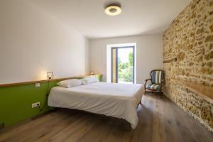 a bedroom with a bed and a brick wall at Villa Charmante au Perigord 10p in Fouleix, Dord in Fouleix +55 photos