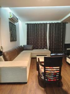 a living room with a couch and a table at BLOSSOM Studio in Manesar