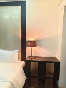 a bedroom with a bed and a table with a lamp at BLOSSOM Studio in Manesar