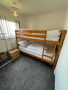 two bunk beds in a room with a lamp at 141 -Two bed Chalet on Sunbeach Holiday Park - Sleeps 6, pet friendly, FREE pool and entertainment passes included - plus WiFi with bedding and towels included - only 300m from the beach! in Scratby +23 photos