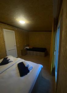 Mountain Hut في كازباجي: غرفة نوم بسرير ابيض ونافذة