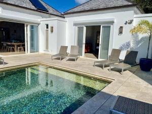 a swimming pool with chairs next to a house at Lookout in Bolans