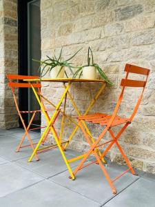 a table and two chairs next to a wall at L'Hermine terrasse et parking, 500 plage in Concarneau