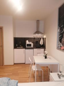 eine Küche mit einem weißen Tisch und weißen Stühlen in der Unterkunft Studio brand new apartment #28 in new building with free parking in city center in Prag
