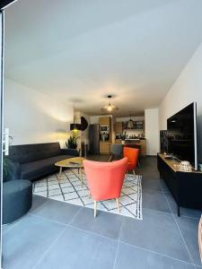 ein Wohnzimmer mit einem Sofa und einem Tisch in der Unterkunft L’Hermine, parking & terrasse in Concarneau