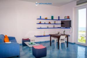 a living room with a blue couch and a table at Ostia Holiday Al Curvone 2 in Lido di Ostia