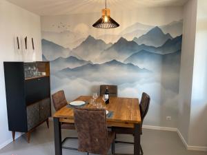 a dining room with a mountain mural on the wall at Le Clos Des Buis Gîte de Charme AZUL in Cazals