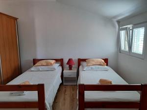 two twin beds in a room with a window at Apartmani Gojko in Sali