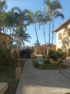 un parco con palme e un marciapiede di Condomínio Villagio Maranduba - Apenas 5 min á pé da praia - Bl 7 a Ubatuba