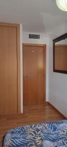 um quarto com uma cama e 2 portas de madeira em HABITACIÓN PRIVADA EN PISO a 10 minutos de Atocha em Madri