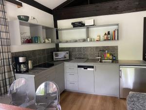 a kitchen with white cabinets and silver appliances at Ferienwohnung Thalia in Berg am Starnberger See