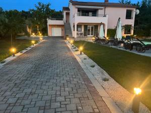 uma entrada de tijolos com luzes em frente a uma casa em Villa Orka em Labin