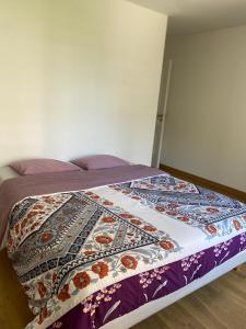 a bed with a colorful quilt on it in a room at Strasbourg appartement moderne in Strasbourg