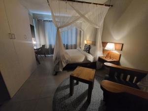 1 dormitorio con 1 cama con dosel en Sundown Guest House Maputo, en Maputo