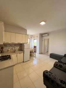 cocina y sala de estar con sofá y mesa en Kamberi Hotel & Apartments en Velipojë