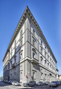 un grand bâtiment avec des voitures garées devant lui dans l'établissement Dedo Boutique Hotel, à Florence