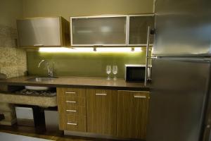 a kitchen with a stainless steel refrigerator and wooden cabinets at Apartamentos Turísticos Pacios in Santiago de Compostela