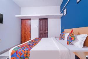 sypialnia z dużym łóżkiem i kolorowym kocem w obiekcie FabHotel Shri Ragavi Gardens w mieście Pīlamedu