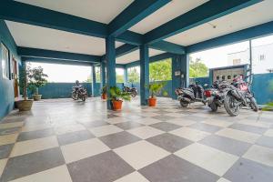 a garage with motorcycles parked on a checkered floor at FabHotel Shri Ragavi Gardens in Pīlamedu