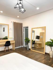 Schlafzimmer mit einem Bett, einem Spiegel und einem Schreibtisch in der Unterkunft Street View Hotel & Apartment in Da Lat