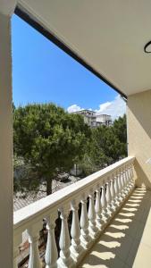 a balcony with a white railing with a view of a beach at Kamberi Hotel & Apartments in Velipojë