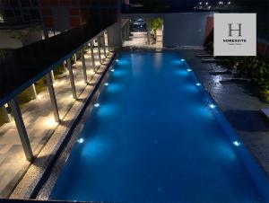 una piscina azul con luces en el lateral de un edificio en Homexuite Vacation @ Sri Indah, en Sandakan