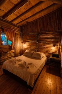 ein Schlafzimmer mit einem Bett in einem Blockhaus in der Unterkunft Alma Hotel Campestre in Santa Elena