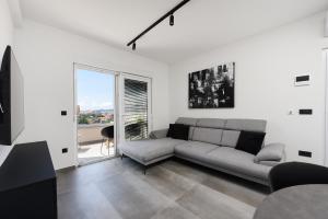 a living room with a couch and a large window at Luxury apartment N in Zadar