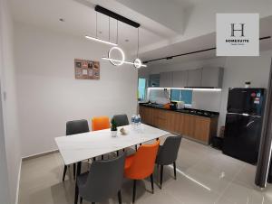 a kitchen and dining room with a white table and chairs at Homexuite Vacation @ Sri Indah in Sandakan